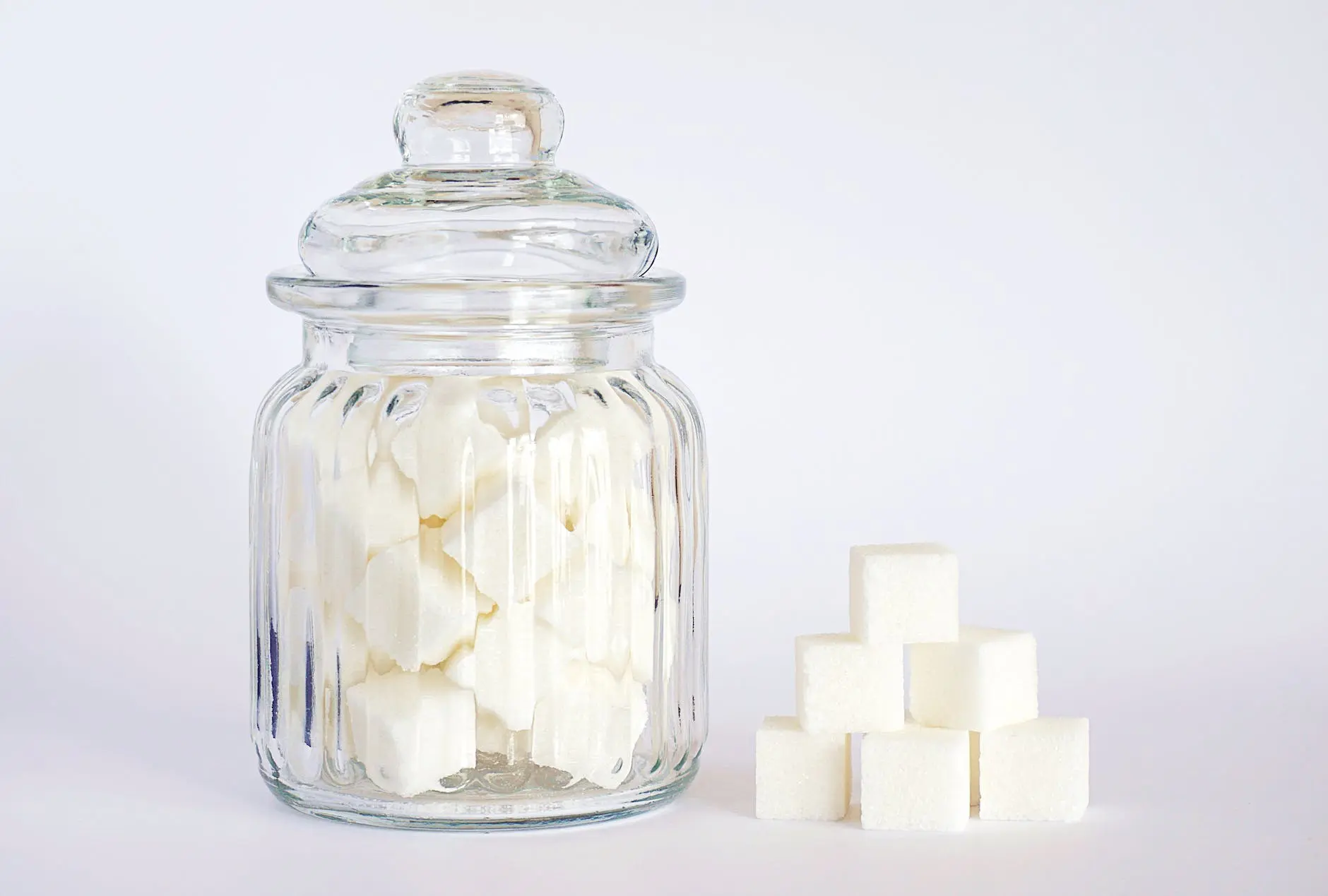 close up photo of sugar cubes in glass jar